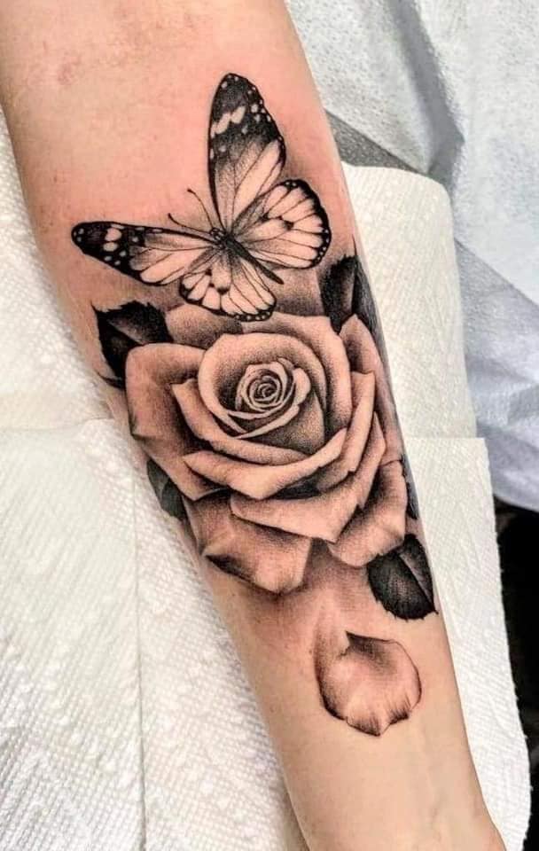 9 Tatuajes de Mariposas Negras con rosa y hojas negras en antebrazo