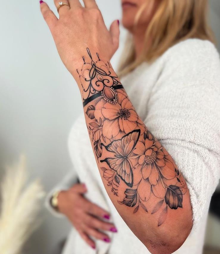 6 Chik Tattoo auf dem Unterarm mit Schmetterlingsblütenblättern und Armband mit Ornamenten
