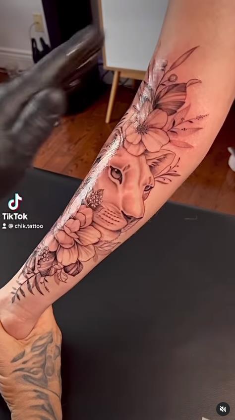 7 Chik Tattoo lionne parmi la végétation naturelle sur l'avant-bras