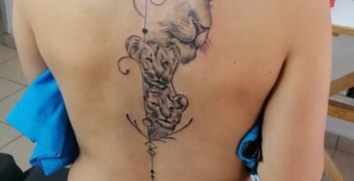 552 Tatuajes Originales mas Gustados Leon en espalda con dos cachorros a lo largo de la columna con flecha