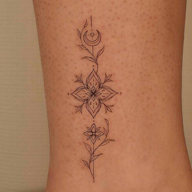 44 Tatuagens Simples Pequenos enfeites de flores simétricas, trevo de quatro folhas e lua na panturrilha