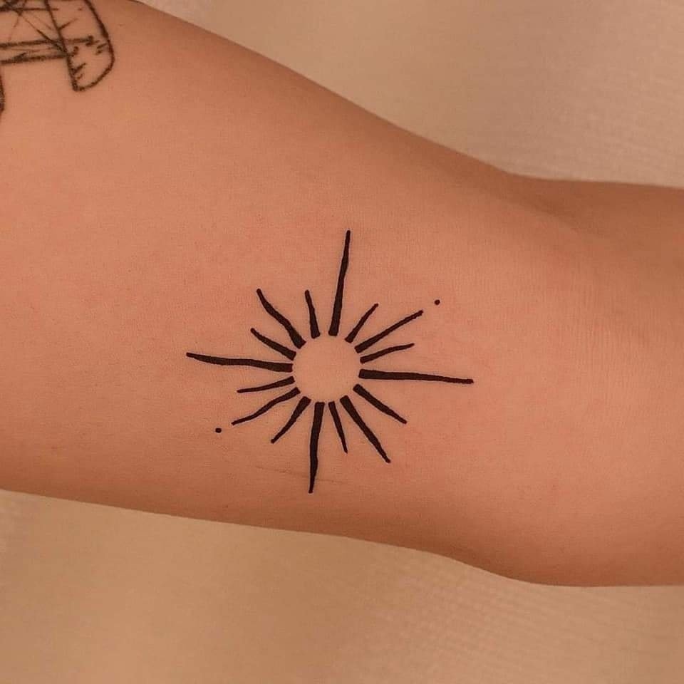 73 tatuagens simples para mulheres Sol com raios pretos simétricos no braço