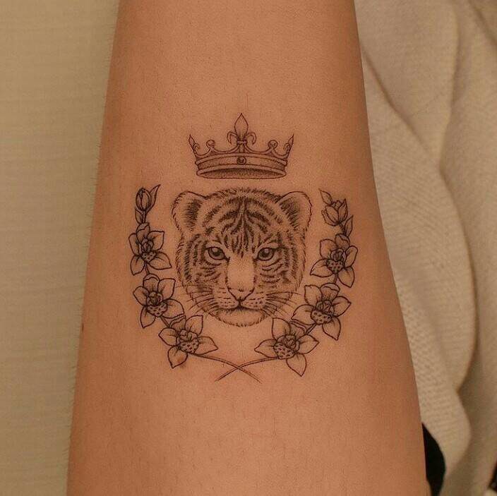 83 Semplici tatuaggi per donne: cucciolo di leone con corona e alloro sul braccio