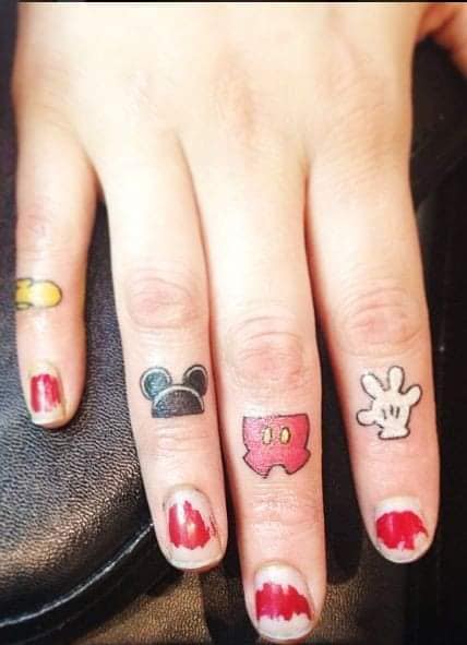 23 petits tatouages Mickey sur chaque doigt de la main