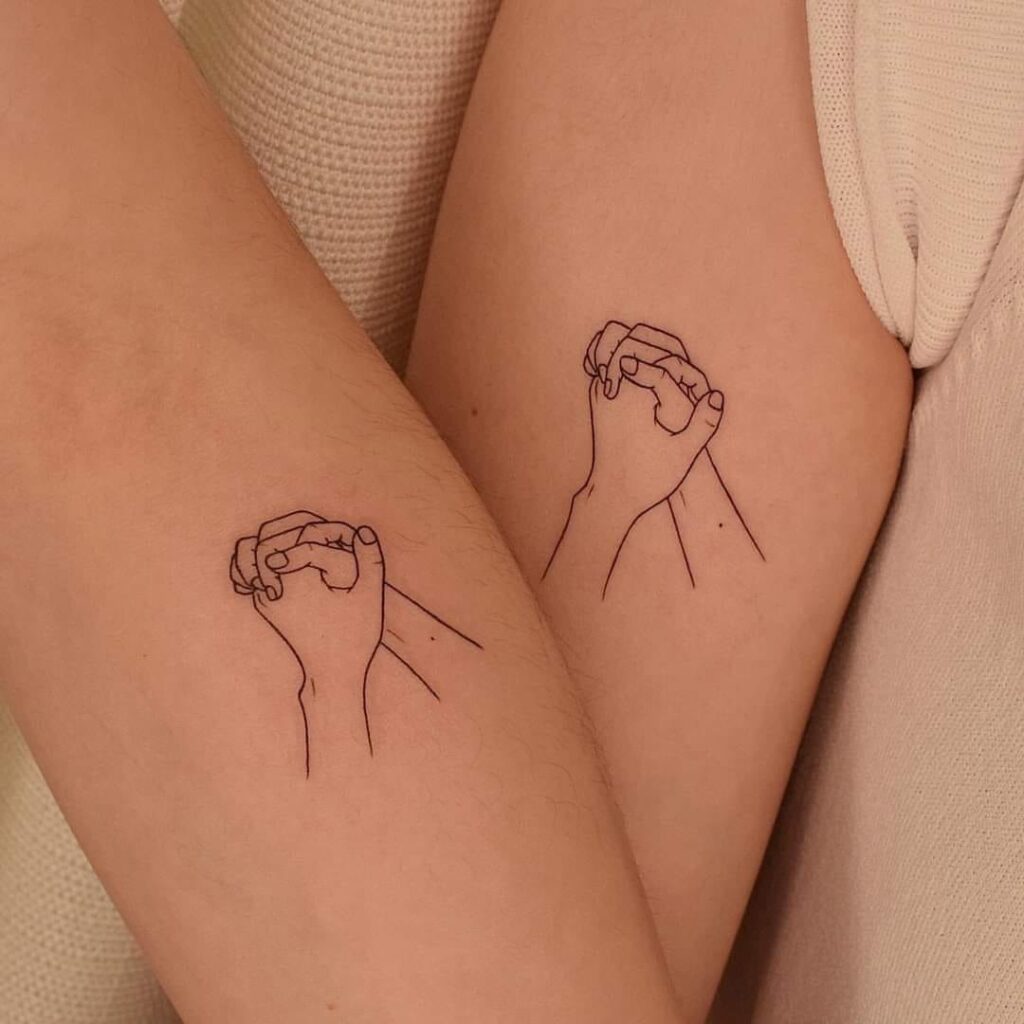 61 Small Tattoos for Couples Hands with fingers intertwined on the arm