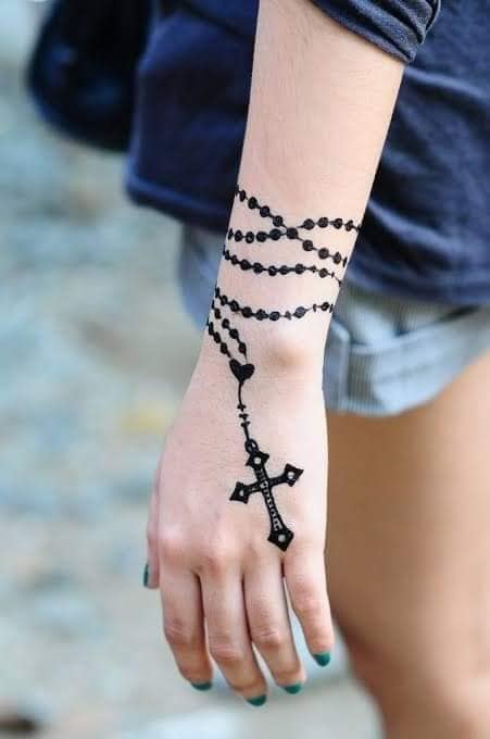 108 Tatuajes de Rosarios Negro anudado en la muneca y cruz sobre la mano