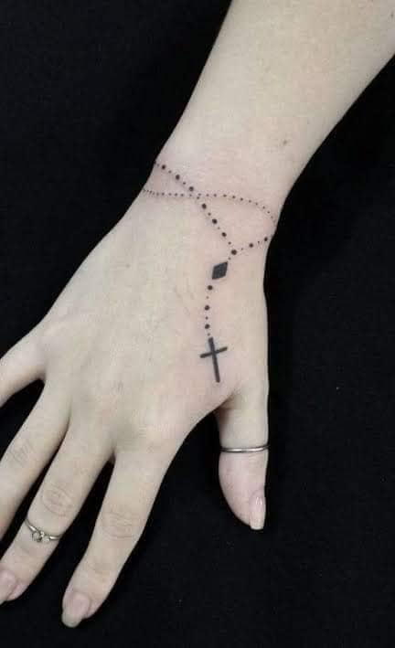 81 Tatuajes de Rosarios con pequena cadenita delicada y cruz sobre la mano negro