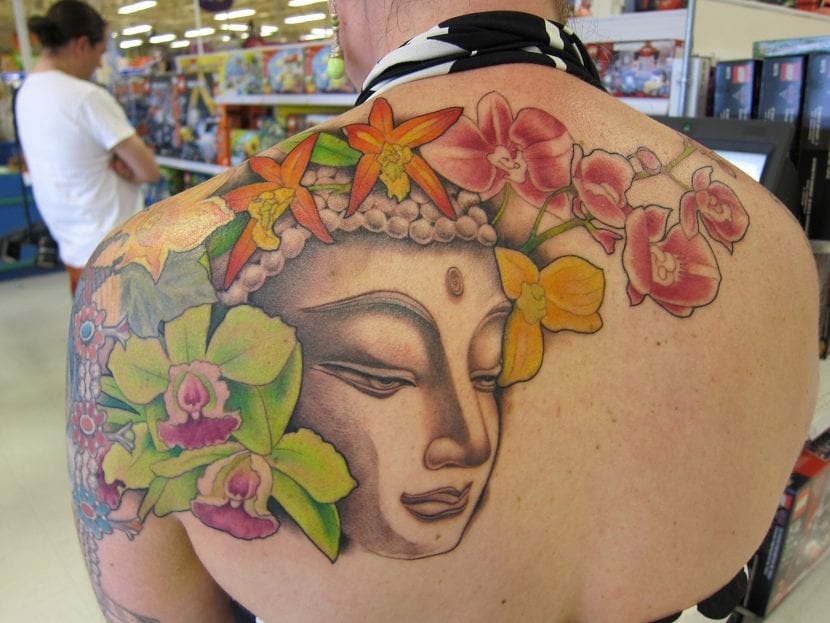 12.2 Beautiful orchid and buddha tattoo on the back and part of the arm of a woman