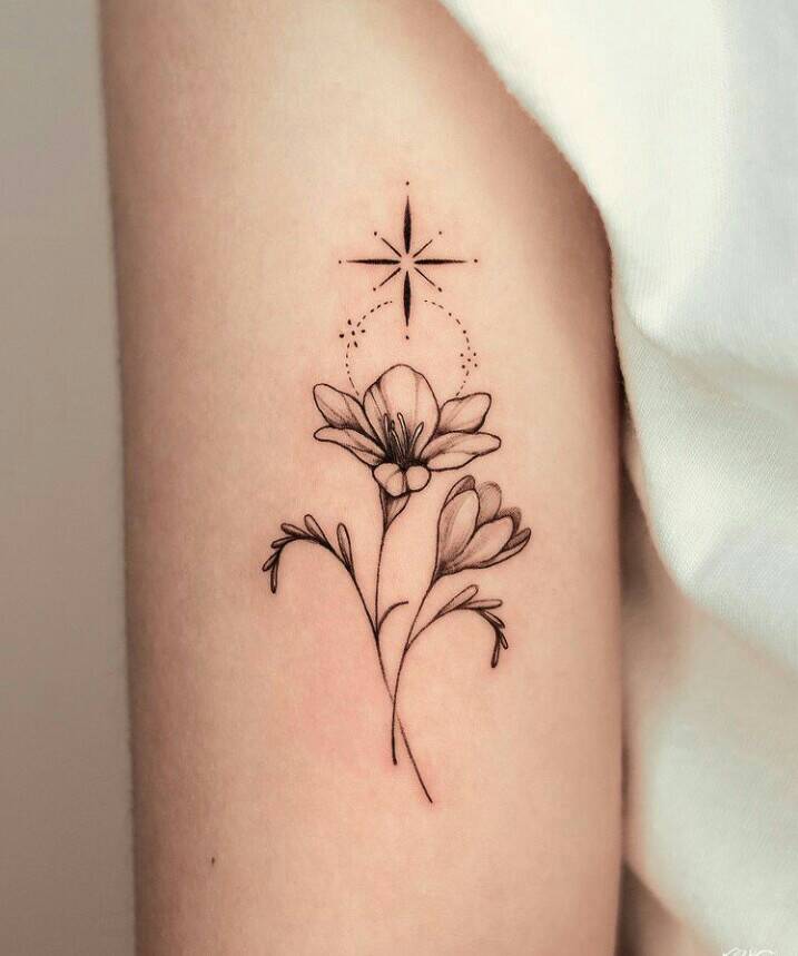 135 wunderschönes Tattoo einer Blume auf dem Arm einer Frau mit einem Stern