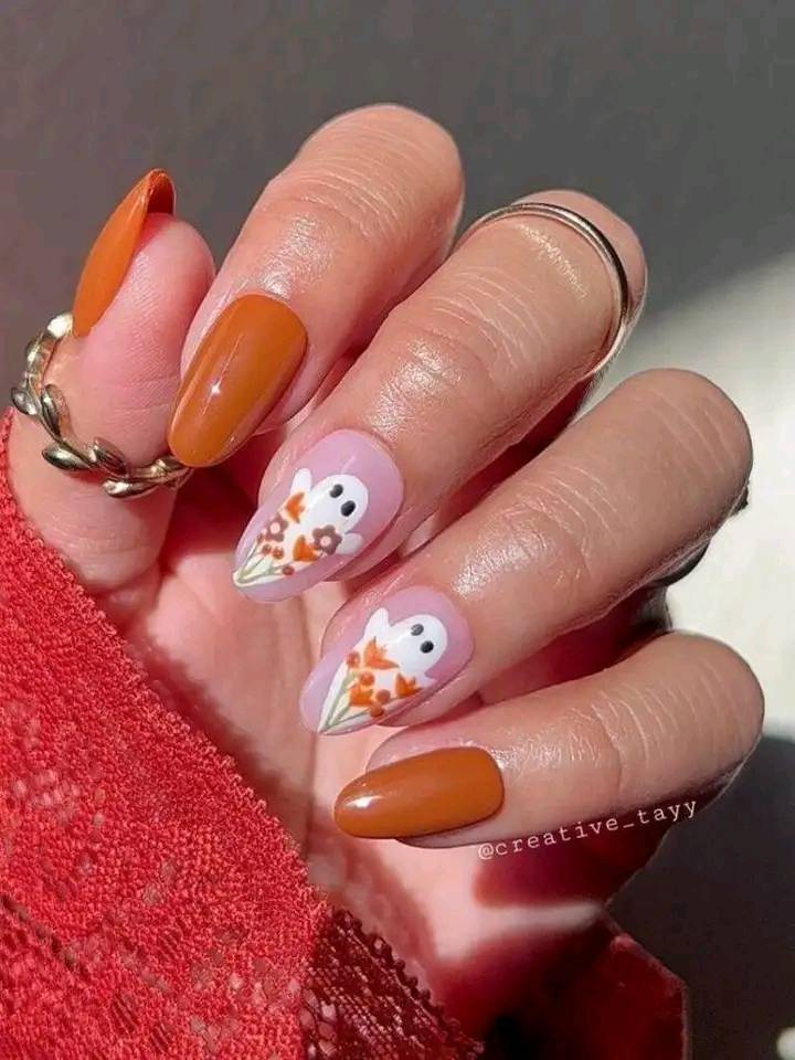 32 unghie decorate con fantasmi di Halloween arancione brillante con fiori su sfondo rosa