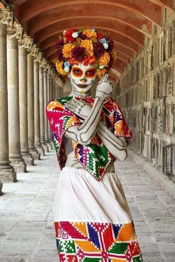 39 La Catrina-Kostüme mit Cempasuchil-Blumen-Make-up in den Augen und Symbolen auf den Gesichtern, Skelett am Körper, Blumenstirnband und traditionellem weißem Kleid mit farbigen Details