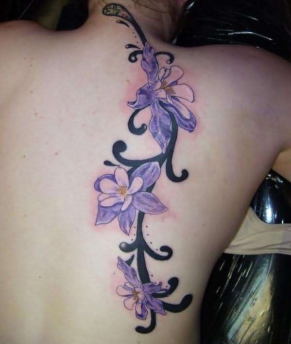 45 Hermoso tatuaje de orquidea en la espalda de una mujer en tonos violetas