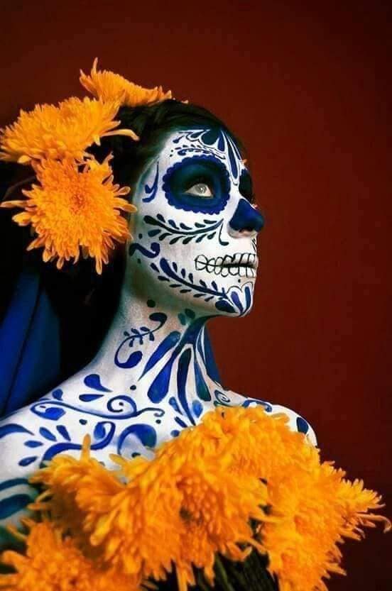 53 Disfraces de La Catrina maquillaje blanco con simbolos en azul en rostro y cuerpo diadema de flores naranja con manto azul rey y vestido largo