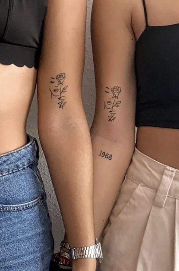 55 Rose Twin Tattoos com contorno facial no braço datado no antebraço