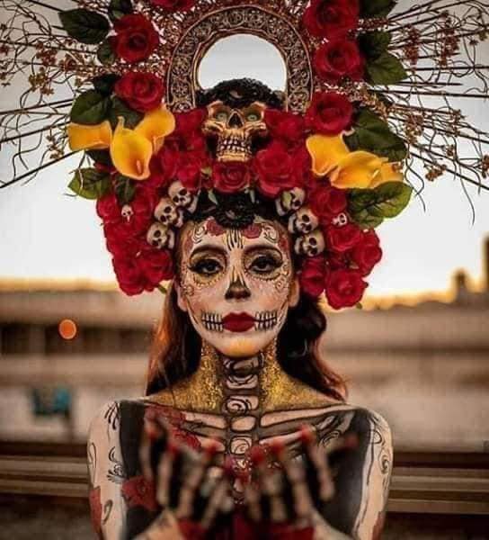73 La Catrina costumes makeup with symbols on the face and skeleton on the body with a headband of red roses, yellow lilies and skulls
