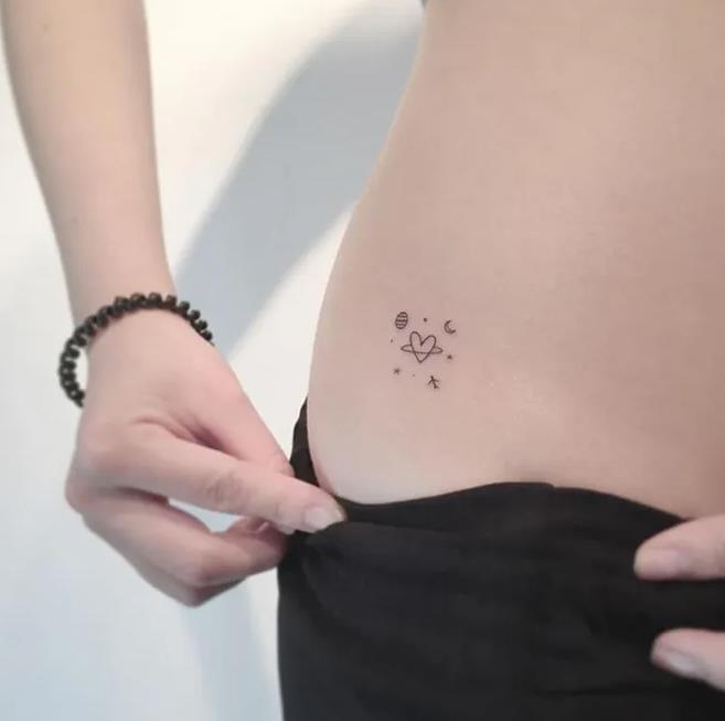 105 Mini Tattos al costado de la ingle corazon con aro de saturno mas planetas y lunas