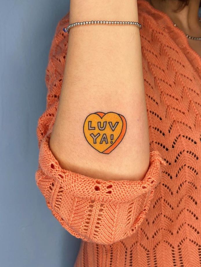 23 ORIGINAL SMALL TATTOOS yellow heart with letter LUV YAI inside on the forearm