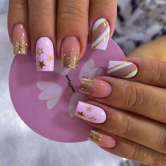 236 Nails with short square stars pink enamel and gold stars on the ring finger nude and frosted on the edge of the middle and little fingers diagonal stripes on the index finger