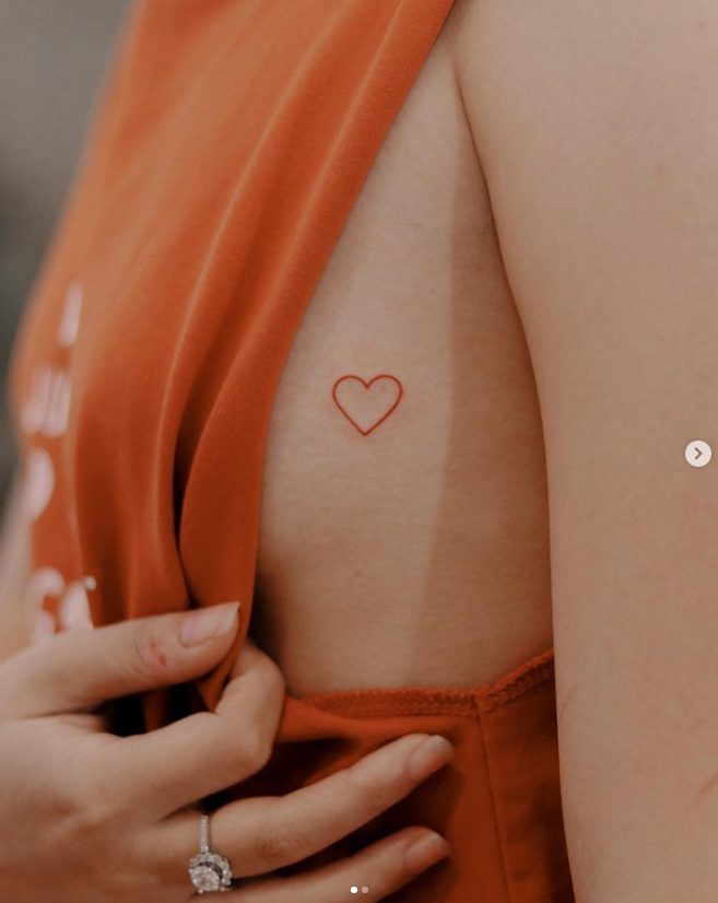 39 Tattoo des Künstlers Nhi.ink mit einem kleinen roten Herzen auf der Brust