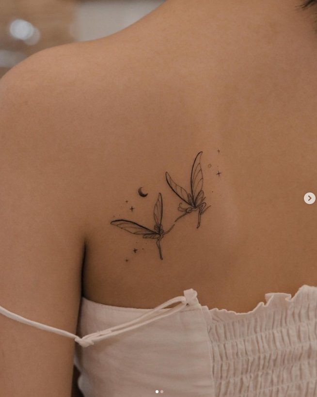 52 tatuaje del artista Nhi.ink de dos adas tocandose los dedos en el hombro