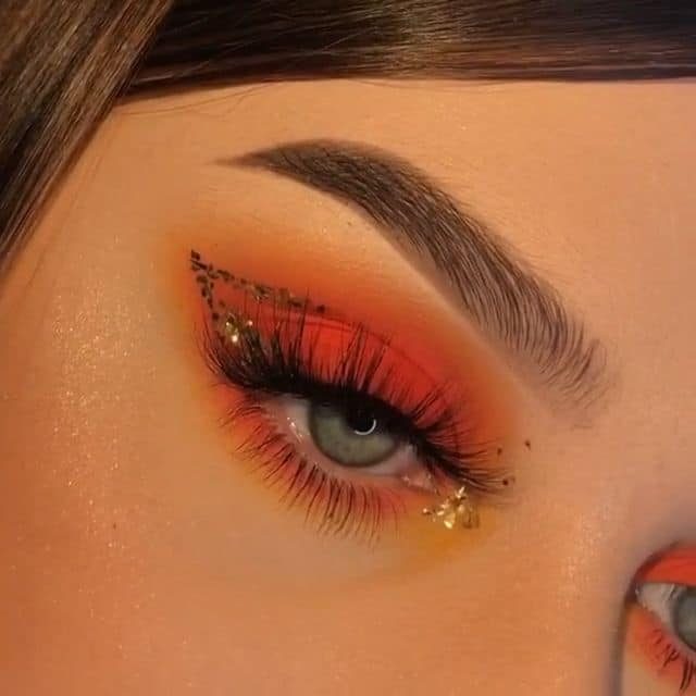 13 Maquiagem em tons laranja olho esfumado com delineador duplo em glitter