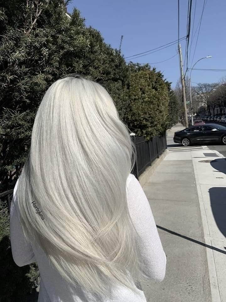 17 White hair straightened with light waves at the ends, length of hair to the lower part of the back