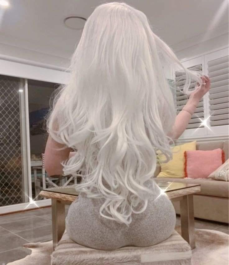 20 White hair straightened with waves at the ends, length of hair to the lower part of the back