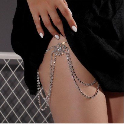32 Body Chains style leg chains with fine chain around the leg holding a flower-shaped pendant and fine double chains dangling