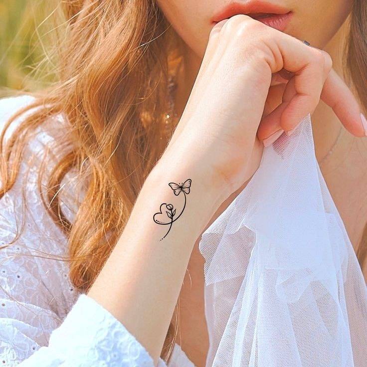 358 Modelo de pequenas tatuagens impressas na lateral do pulso de uma borboleta feminina e delicada flor e coração em preto