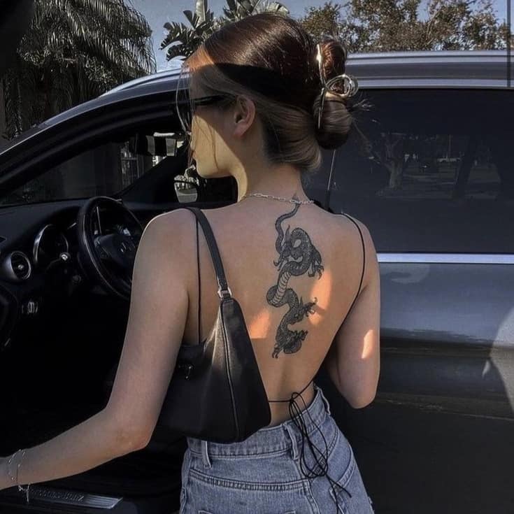 117 tatouages de dos sexy pour les femmes serpent avec des ornements sur le haut du dos en noir