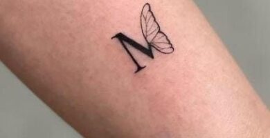 221 Small tattoo letter M with half a butterfly wing on the side of the Forearm
