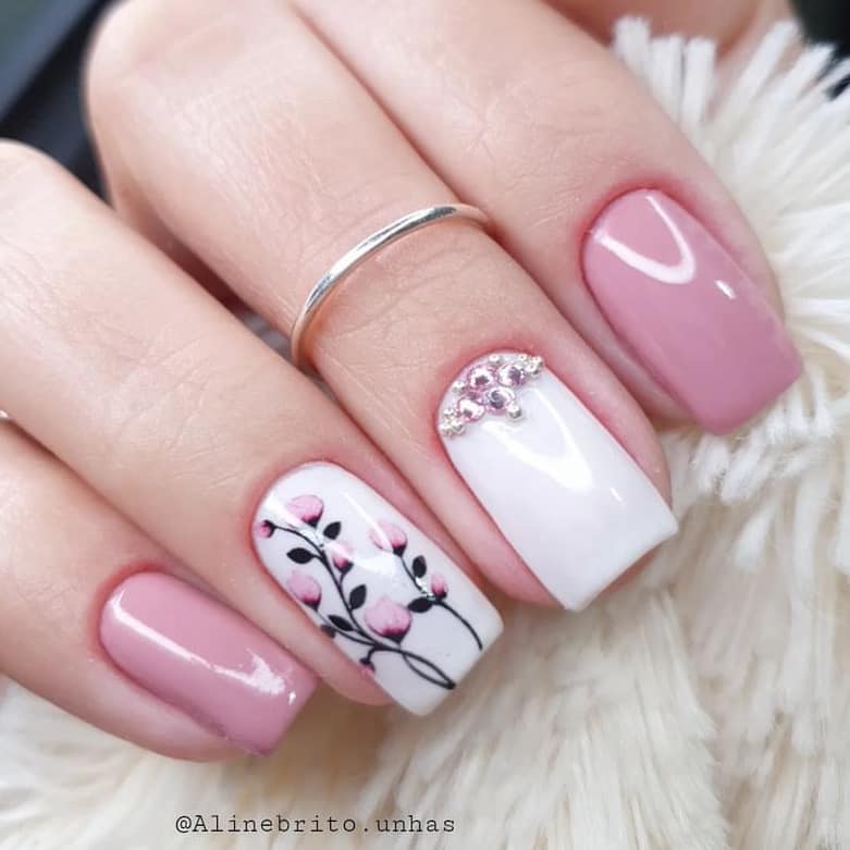 24 designs de unhas quadradas curtas em rosa, strass prateados na base, desenhos de flores em um fundo branco
