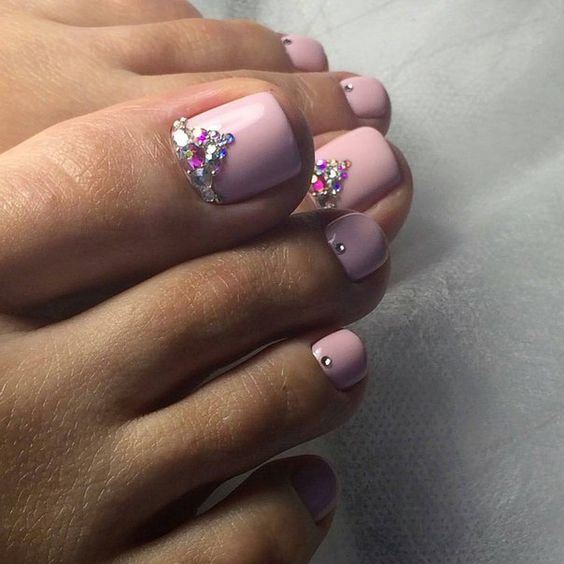 11 Simple nails decorated with elegant pink feet with rhinestones on the shiny silver big toe