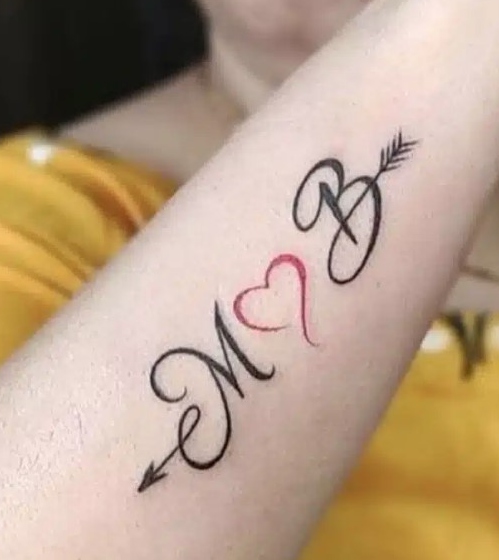 2 Tatuaje en antebrazo con las iniciales M y B flecha y corazon