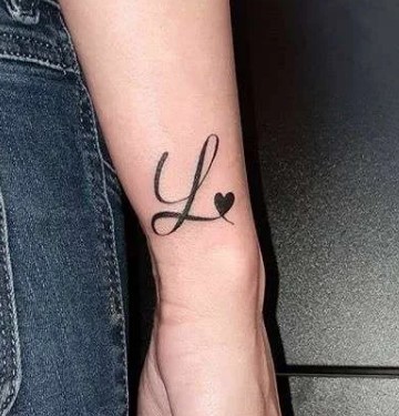 3 Tatuaje con la Letra Inicial L en el costado del antebrazo y un corazon