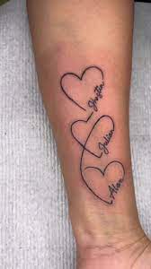 Tatuajes de Iniciales con Corazones tres corazones con nombres en el antebrazo