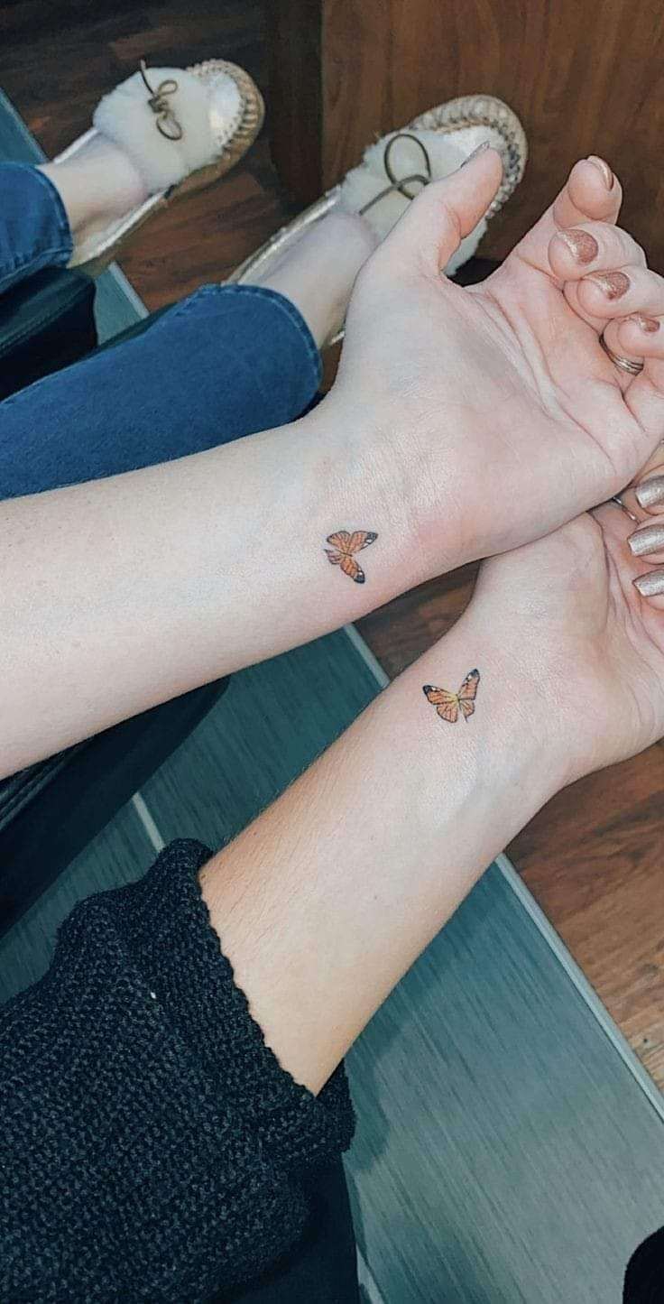 5 Originales tatuajes de mejores amigas dos pequeñas mariposas naranjas en muñeca
