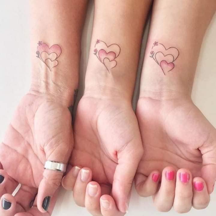 69 Tatuaje de tres amigas tres corazones de tamaños progresivos en muñeca contono rosa
