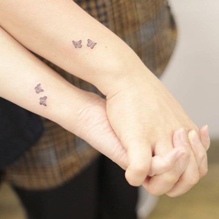 7 Originales tatuajes de mejores amigas dos pequeñas mariposas negras en el costado del barzo