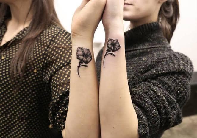 996 Dos amigas con dos flores negras presiosas en en costado del antebrazo Tatuaje