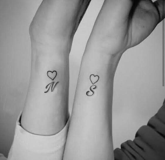 997 Dos amigas con las iniciales de la otra y un pequeño corazon en el dorso del antebrazo Tatuaje