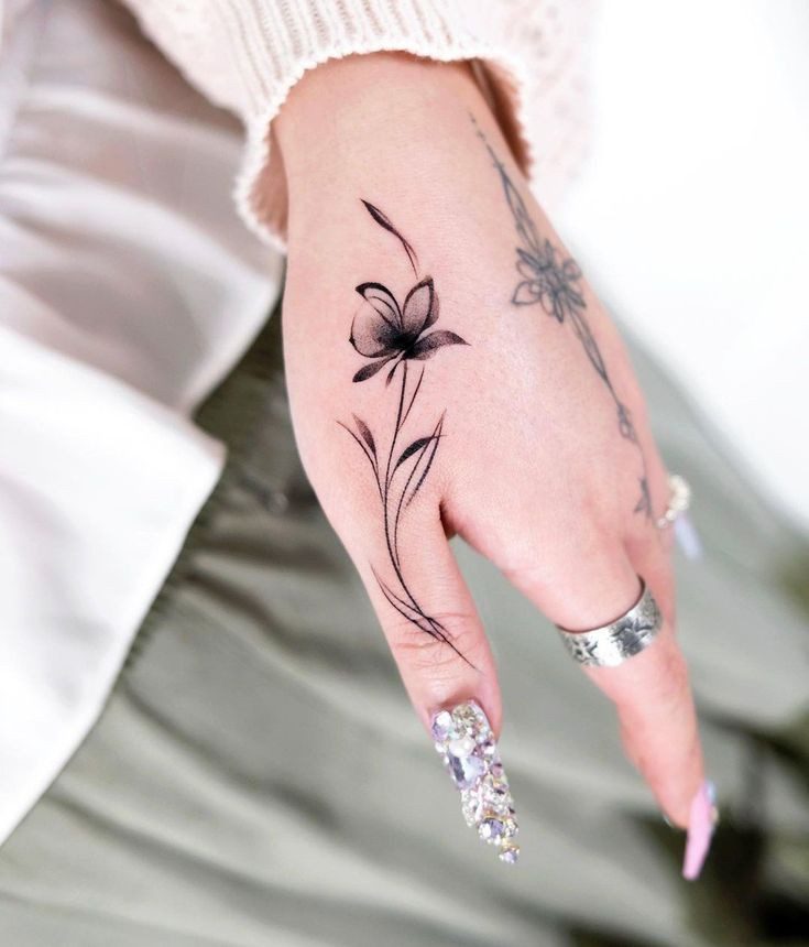 4 TOP 4 Tatuajes Elegantes Negros flor difuminada delicada en el dedo pulgar en mano
