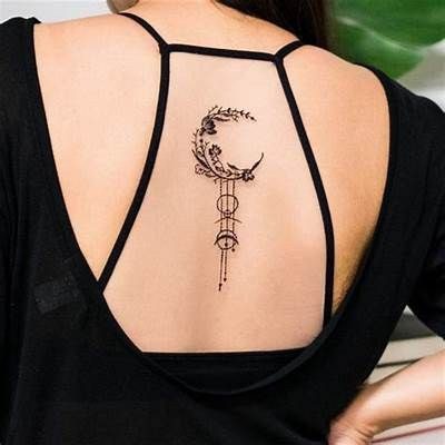 Tatuajes Elegantes Negros Media luna con arreglos de florcitas y ramitas en la parte alta de la espalda