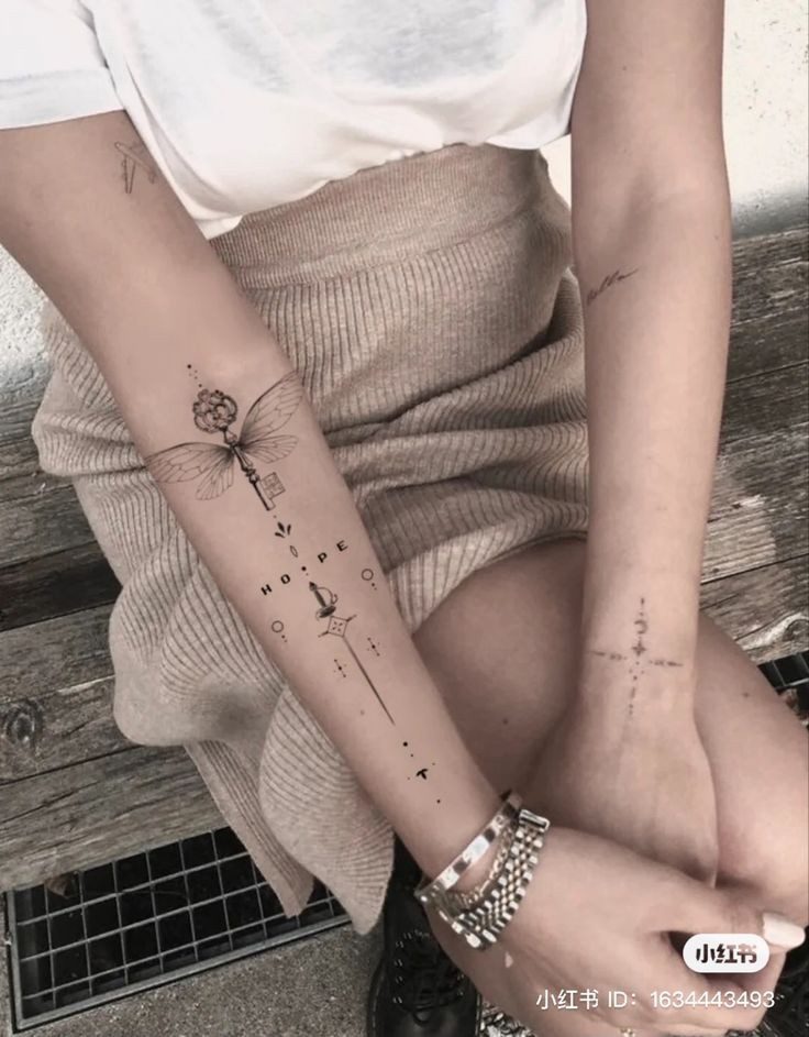 Tatuajes Elegantes Negros dibujo geometrico simetrico en antebrazo con palabra HOPE libelula