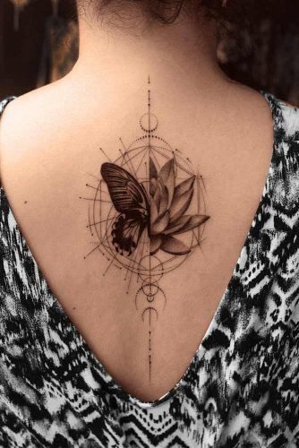 Tatuajes Elegantes Negros dibujo que mezcla un concepto geometrico con mariposa y flor de loto en espalda alta
