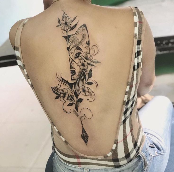 Tatuajes Elegantes Negros media cabeza de zorro con felcha en columna y flores en espalda