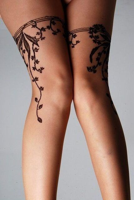 Tatuajes Tattoos en muslo de mujer en forma de liguero con detalles de enredadera