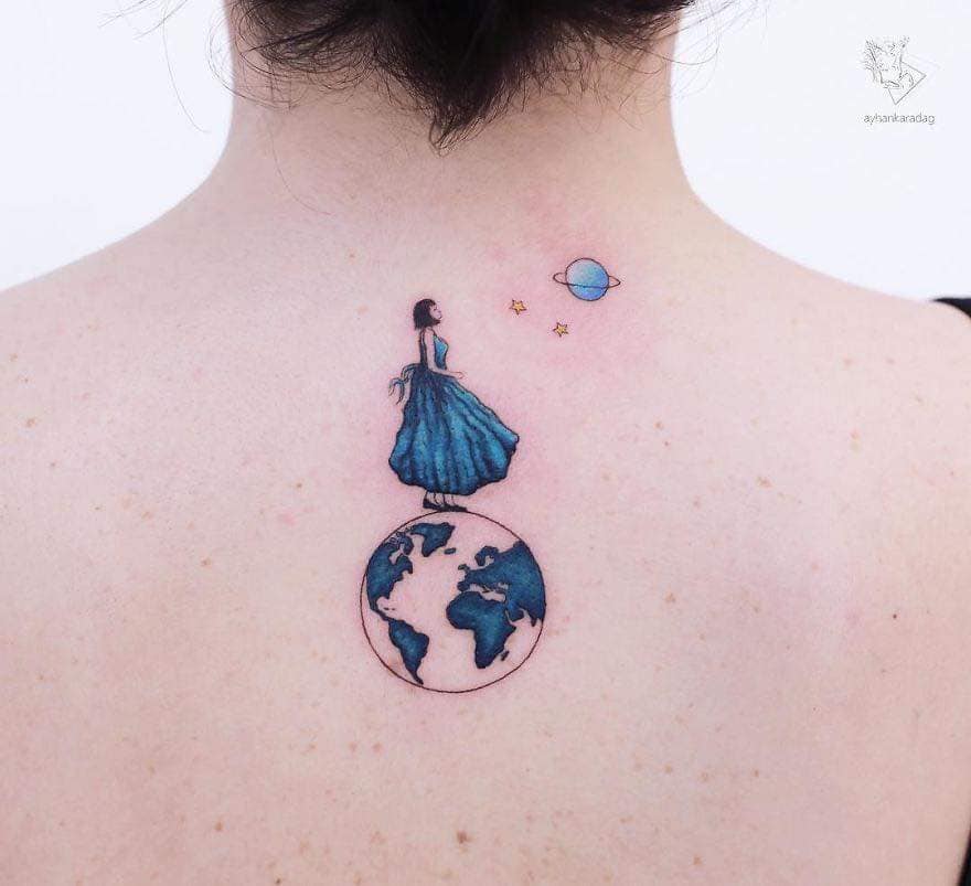 Artistas del Tatuaje Ayhan Karadağ mujer parada sobre la tierra y viendo hacia los planetas