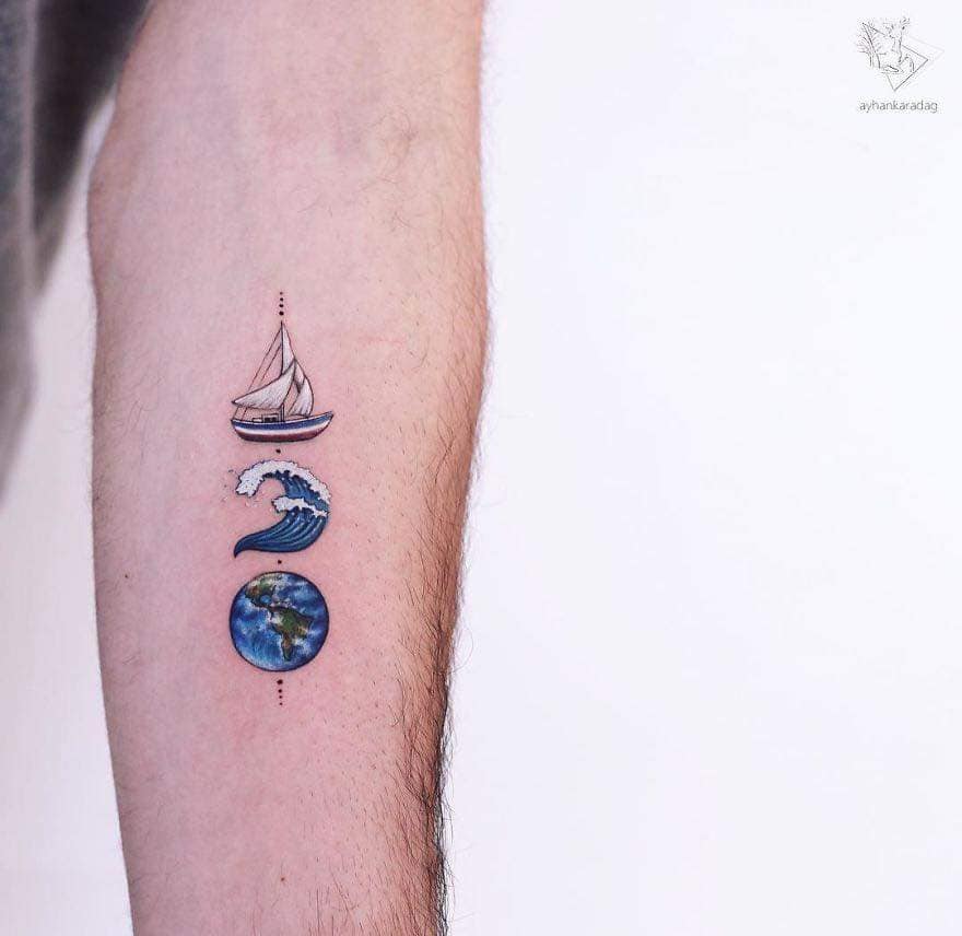 Artistas del Tatuaje Ayhan Karadağ tres en brazo velero ola y tierra