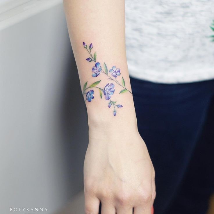 Blumen und Zweige am Unterarm der Frau, hellblaues Armband Typ 9